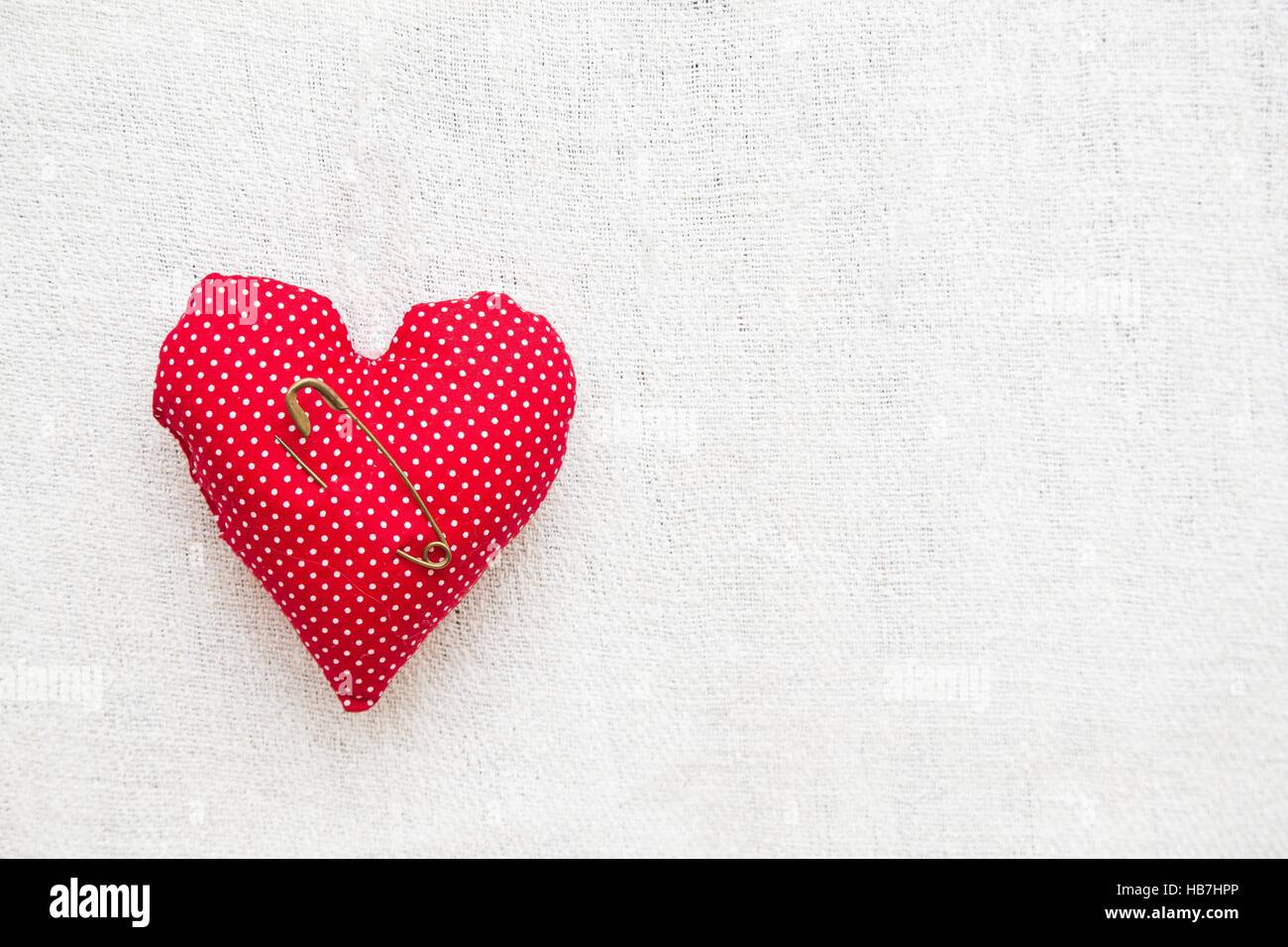 Piccolo a forma di cuore ad ago cuscino su sfondo bianco. Foto Stock