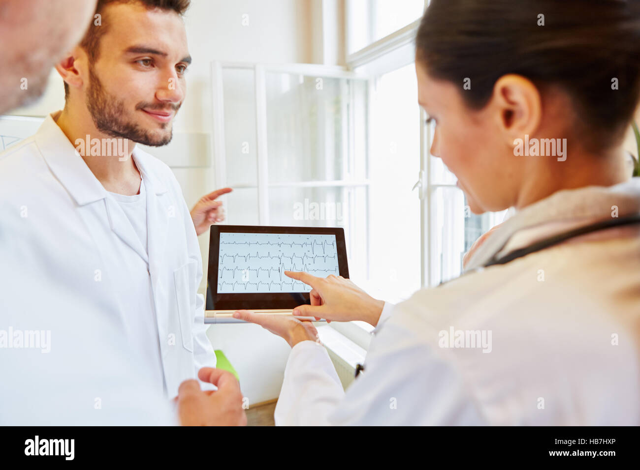 I medici a discutere di ECG diagnostico sul tablet pc Foto Stock