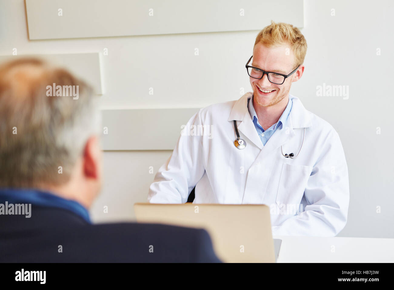 Medico di parlare durante la consultazione con il paziente Foto Stock