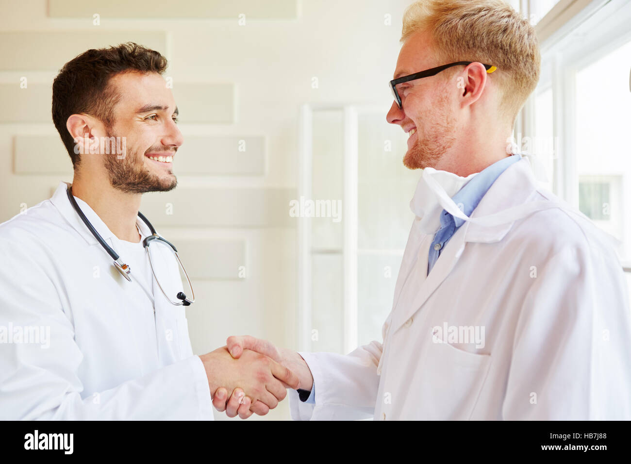 Stretta di mano tra due medici come gesto di benvenuto Foto Stock