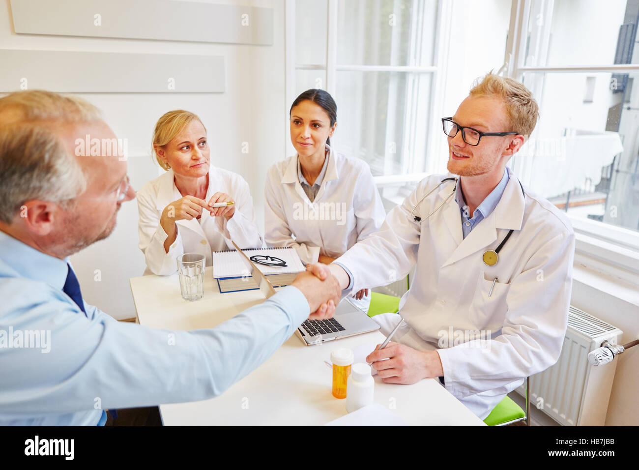 Medico handshake dà al paziente anziano durante la consultazione Foto Stock