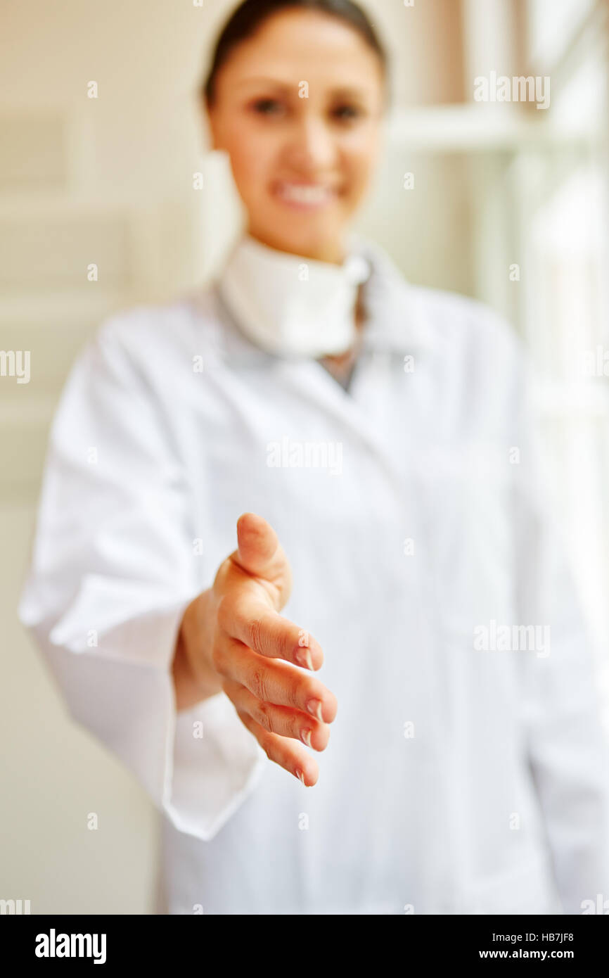 La donna come medico dando stretta di mano come un benvenuto gest Foto Stock