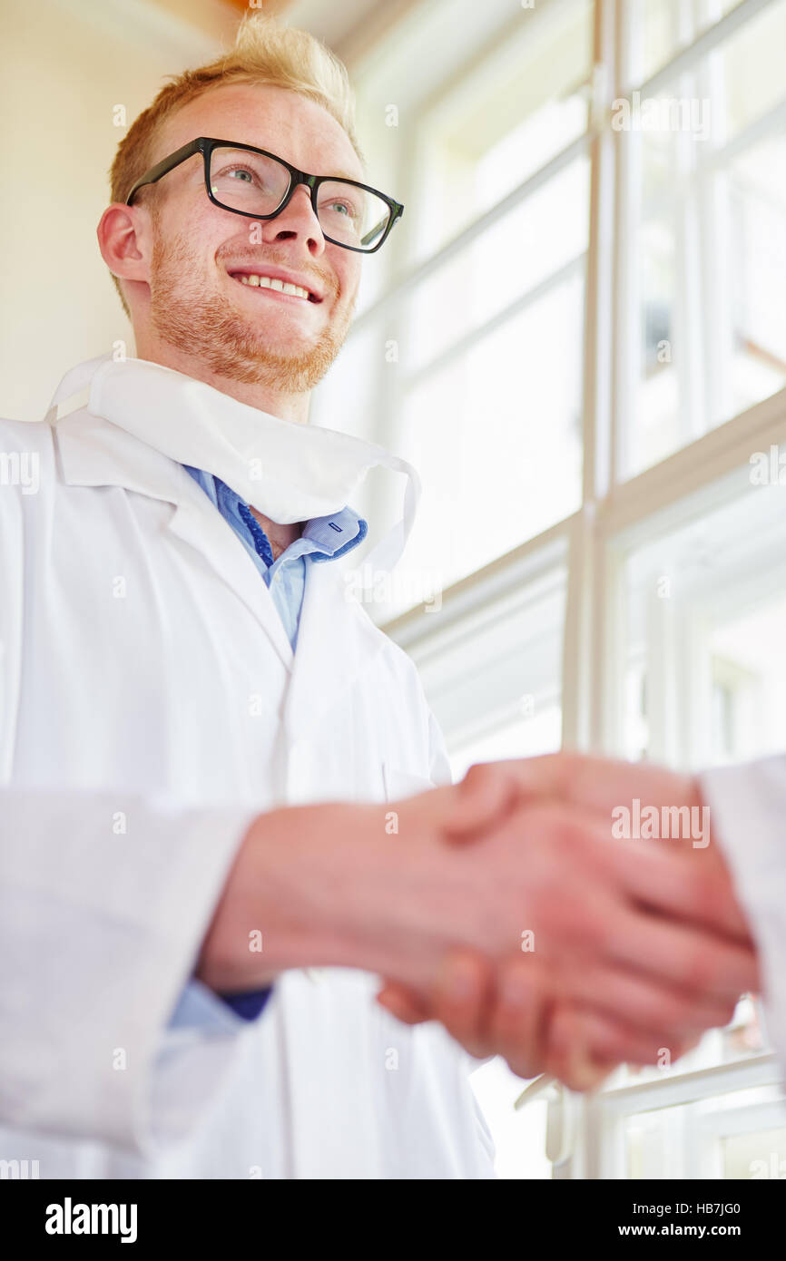 Medico di handshake di condivisione con il medico come accordo e il lavoro di squadra gesto Foto Stock