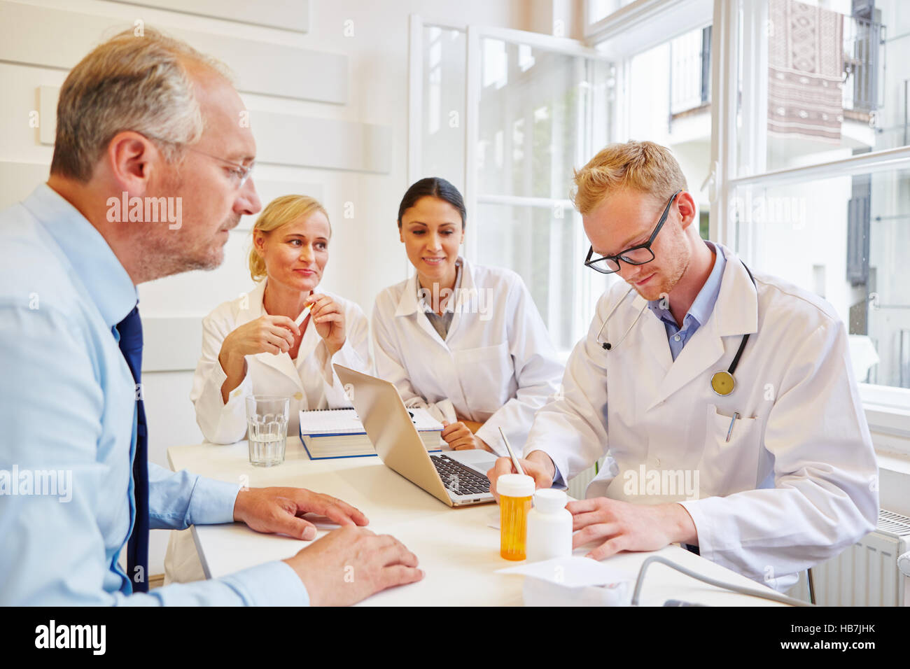 Medico prescrizione di scrittura al paziente senior per il medicamento Foto Stock