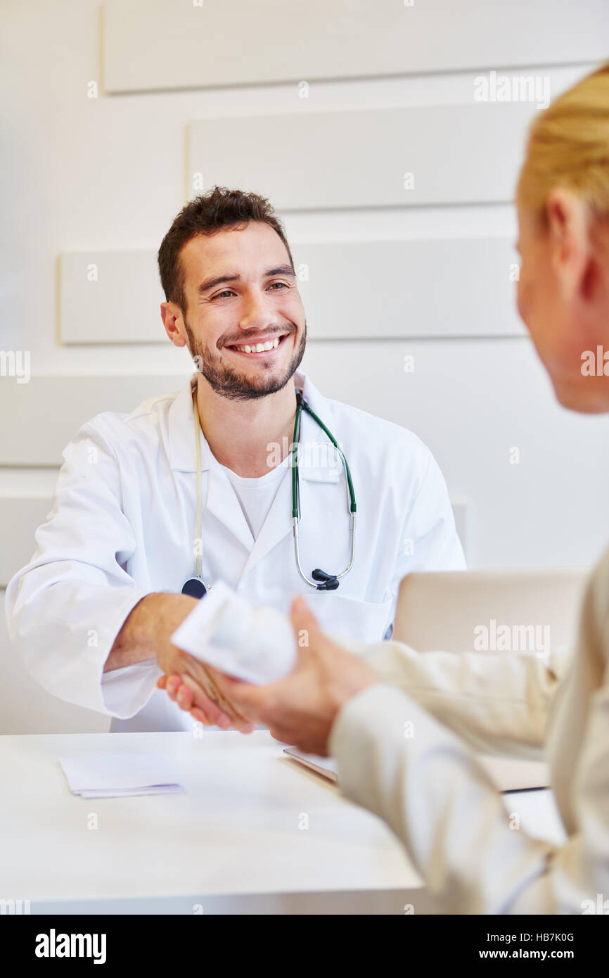 Relazioni di trust paziente medico e handshake dà per ringraziare lui durante la consultazione Foto Stock