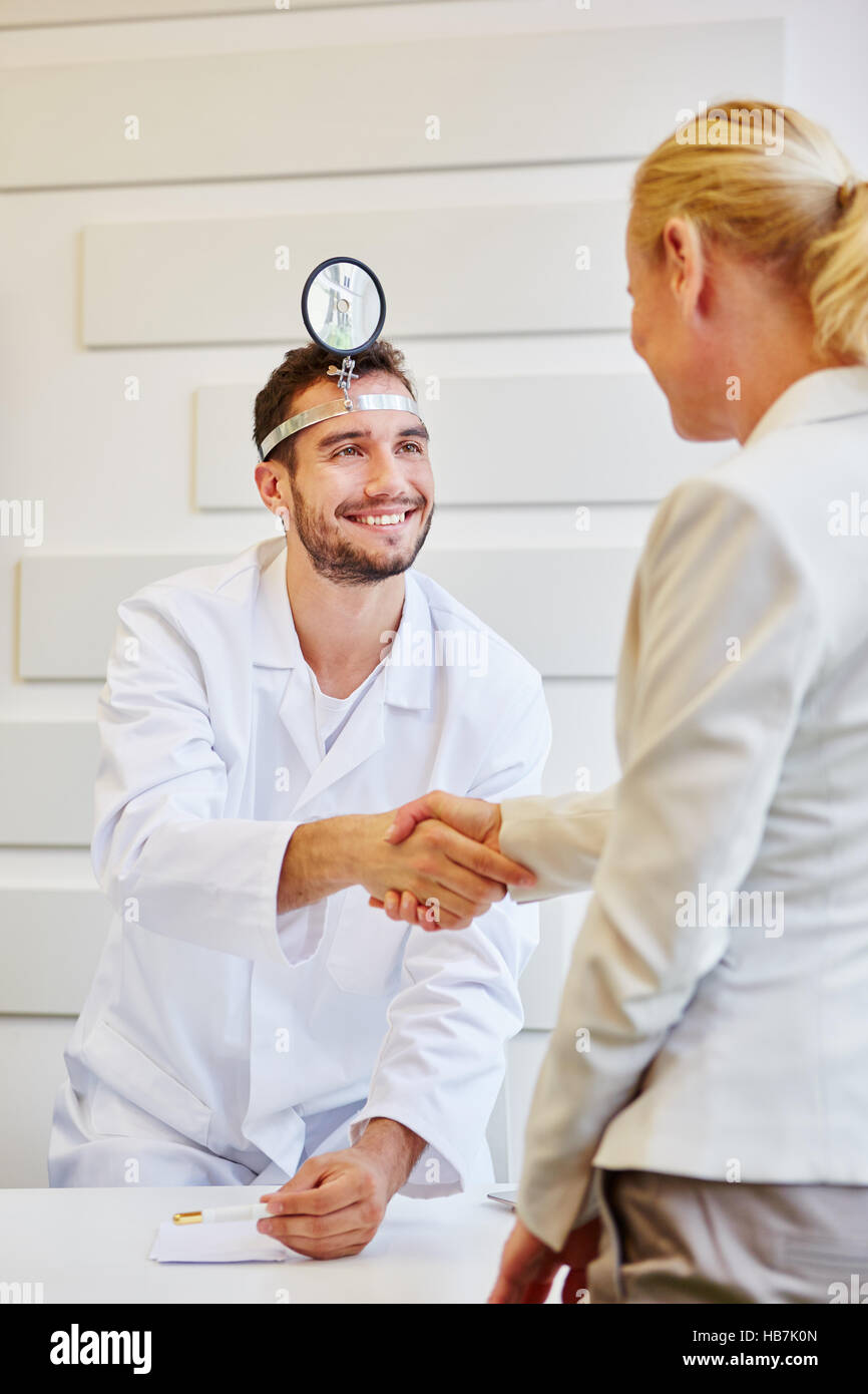 Medico paziente accoglie alla consultazione con handshake Foto Stock