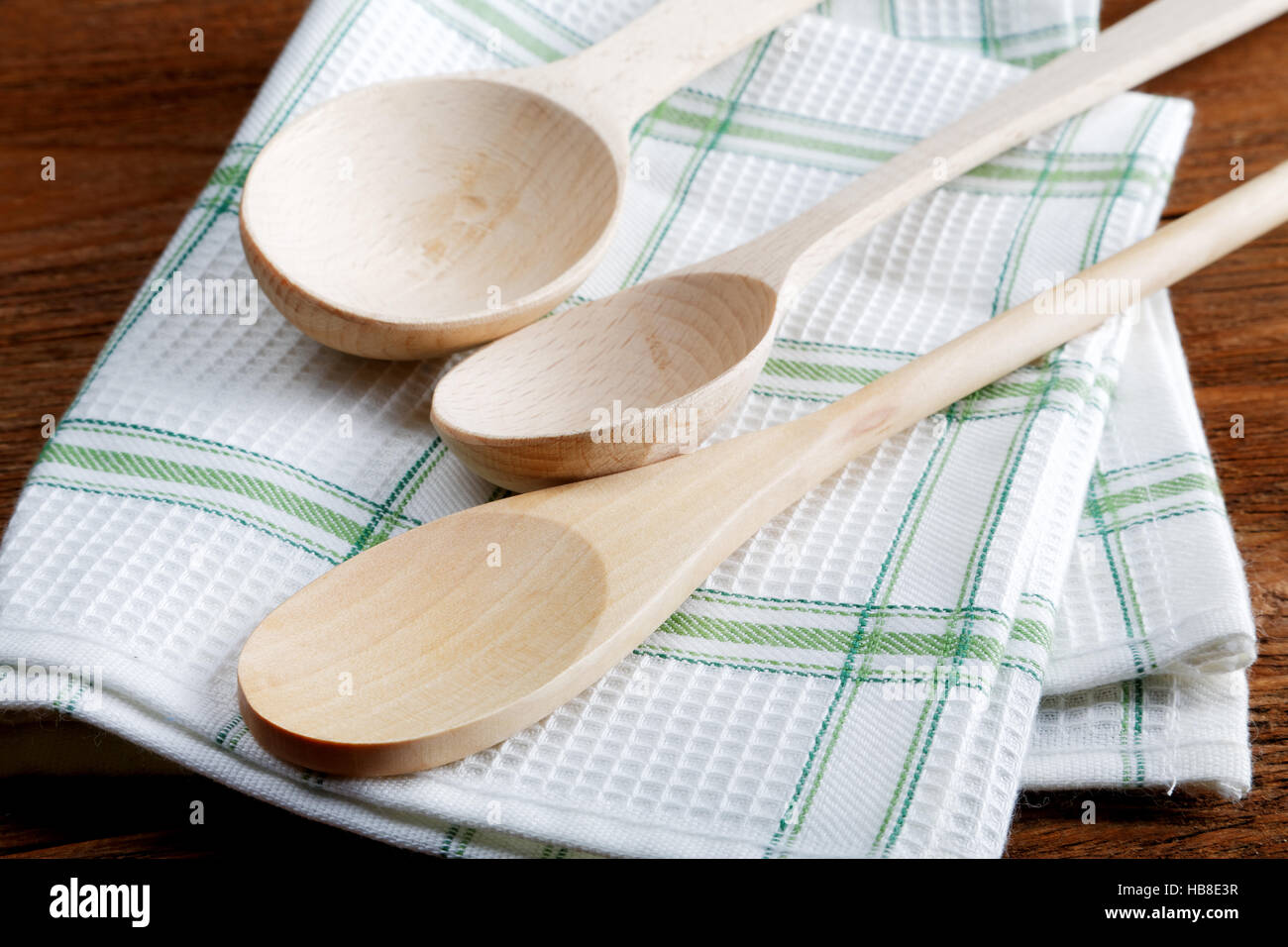 Carta asciugatutto e cucchiaio di legno sul tavolo Foto Stock