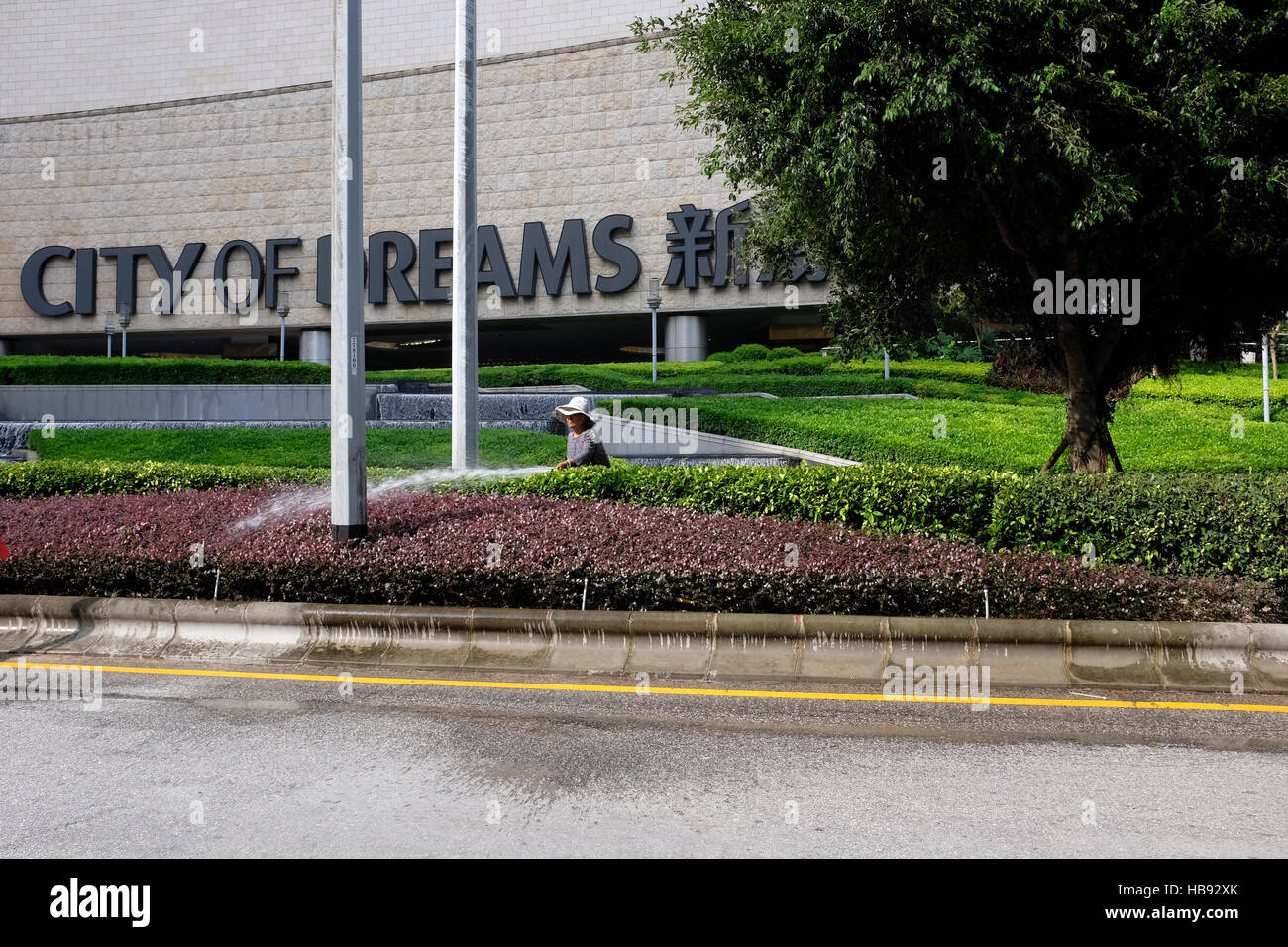 La donna lavoratrice impianti di irrigazione al di fuori della città di sogni casinò di Macau SAR, Cina Foto Stock