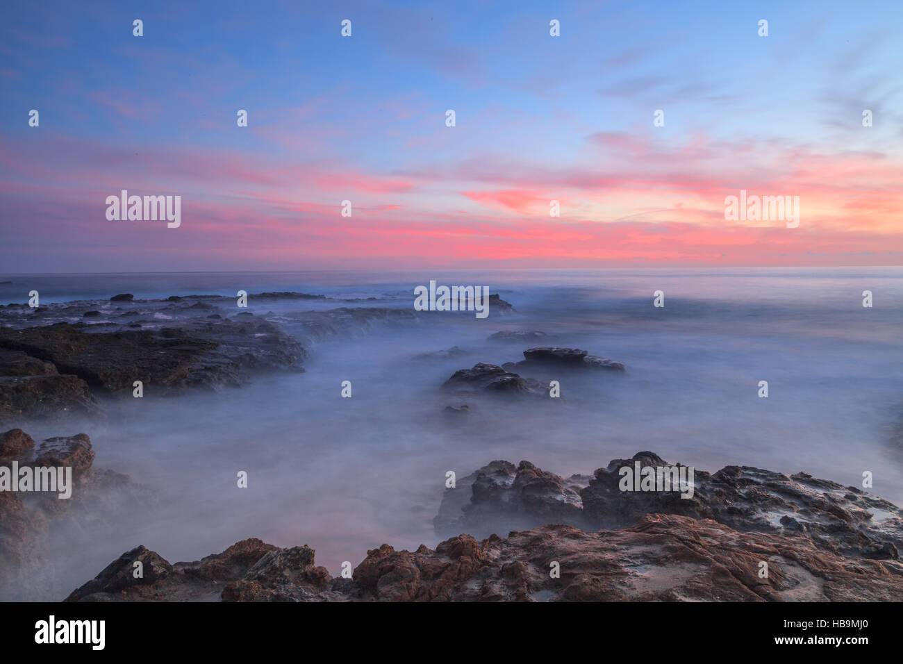 Una lunga esposizione del tramonto su rocce Foto Stock