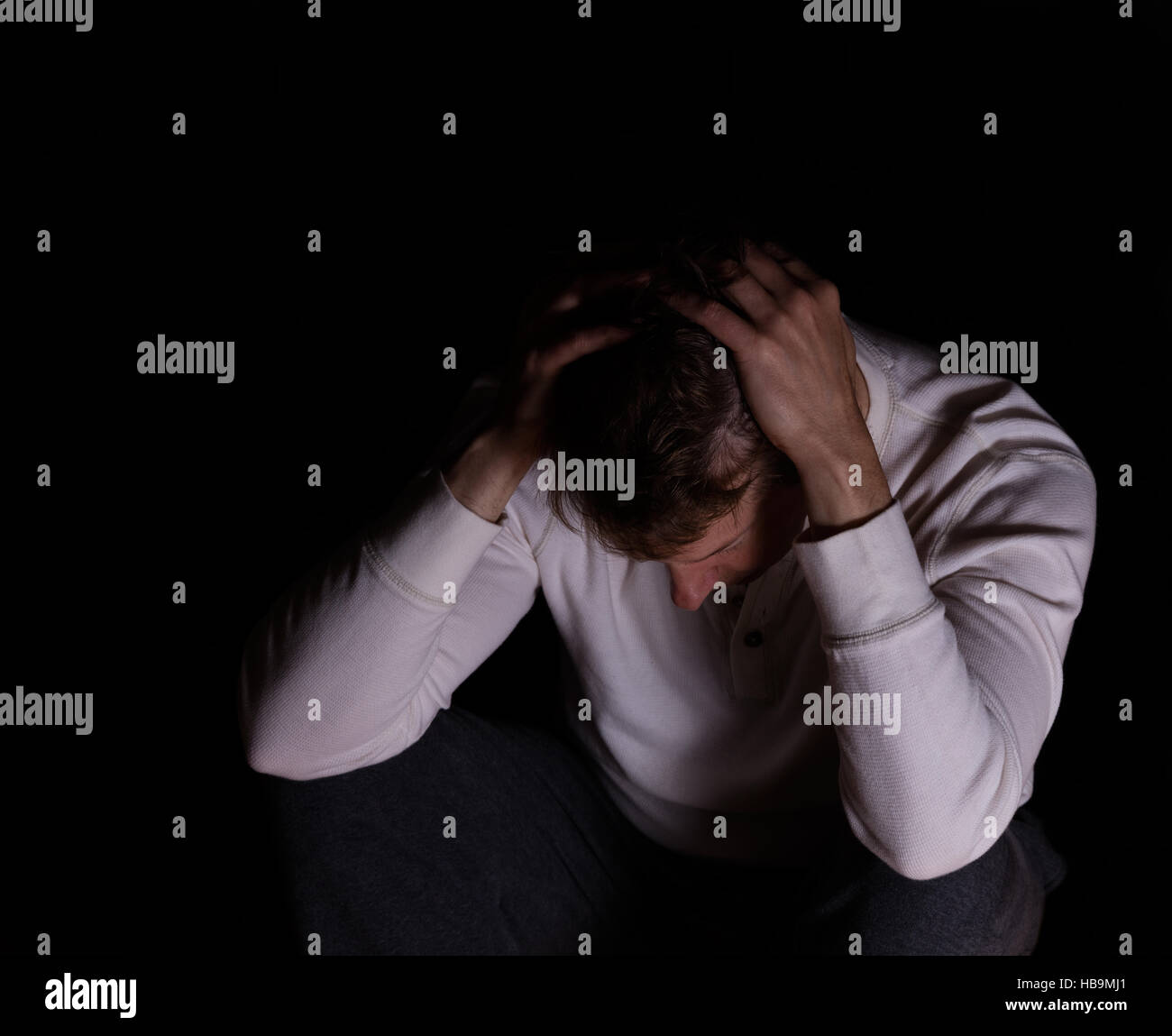 Uomo che mostra la depressione in uno sfondo scuro Foto Stock