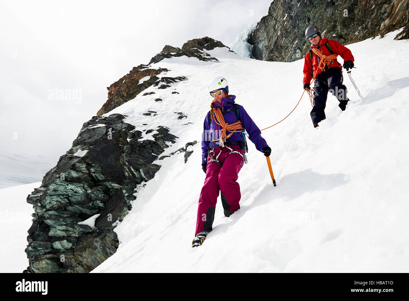 Gli alpinisti scendendo coperte di neve montagna, Saas Fee, Svizzera Foto Stock