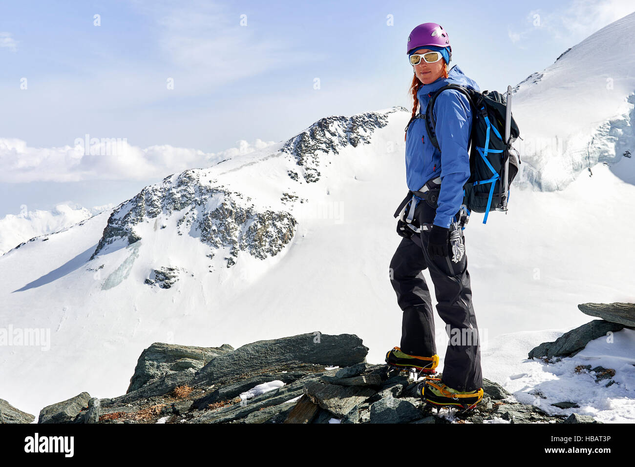 Donna in piedi in cima coperta di neve montagna, Saas Fee, Svizzera Foto Stock