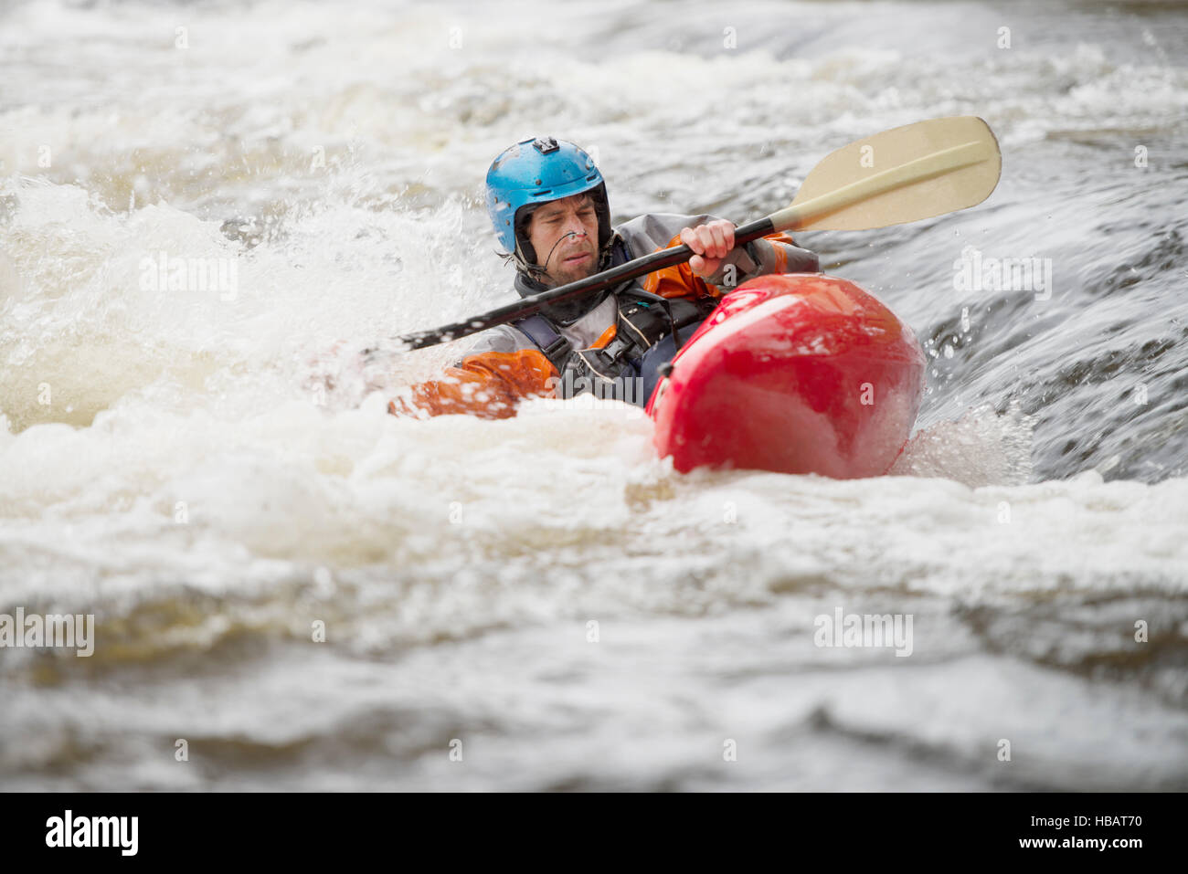 Sbilanciato kayaker maschio canoa fiume Dee rapids Foto Stock
