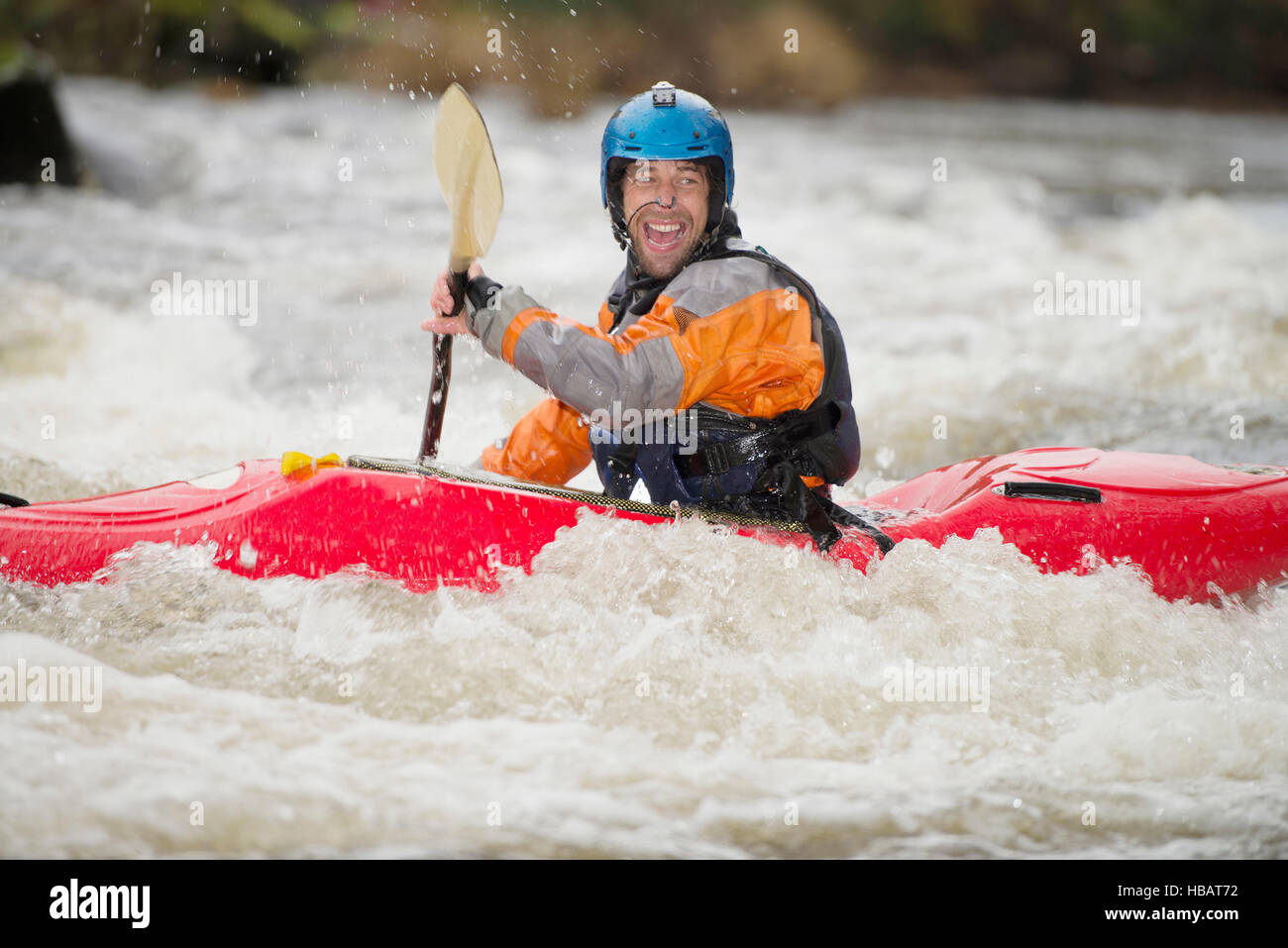 Felice kayaker maschio canoa fiume Dee rapids Foto Stock