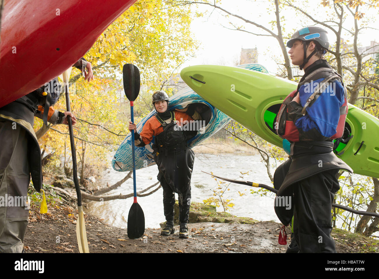 Maschio e femmina porta kayakers kayak sulle rive del fiume Dee Foto Stock