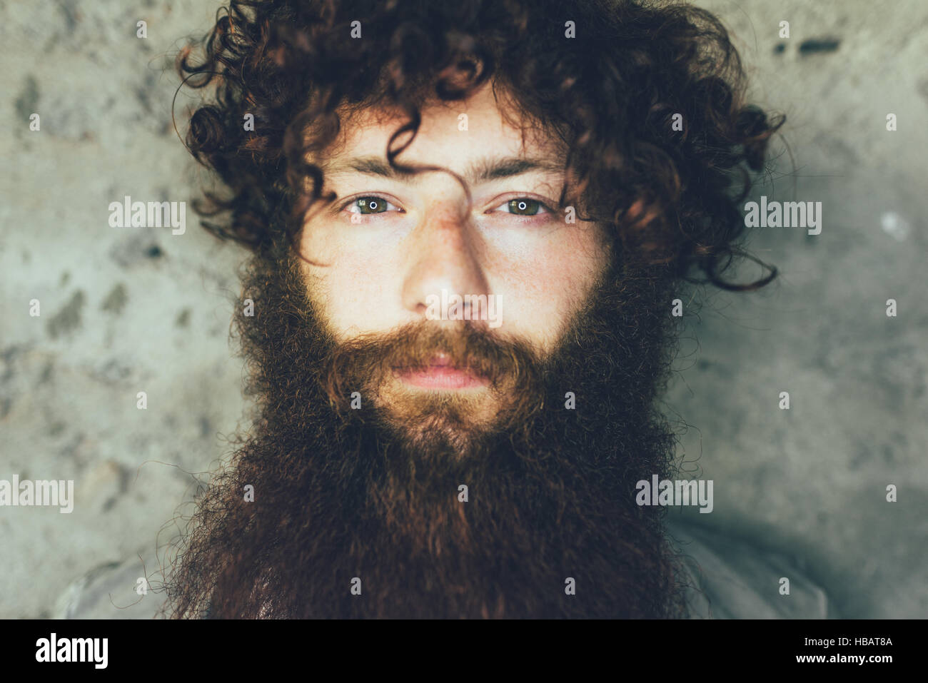 Close up ritratto di Giovane Maschio hipster marrone con capelli ricci e la barba Foto Stock