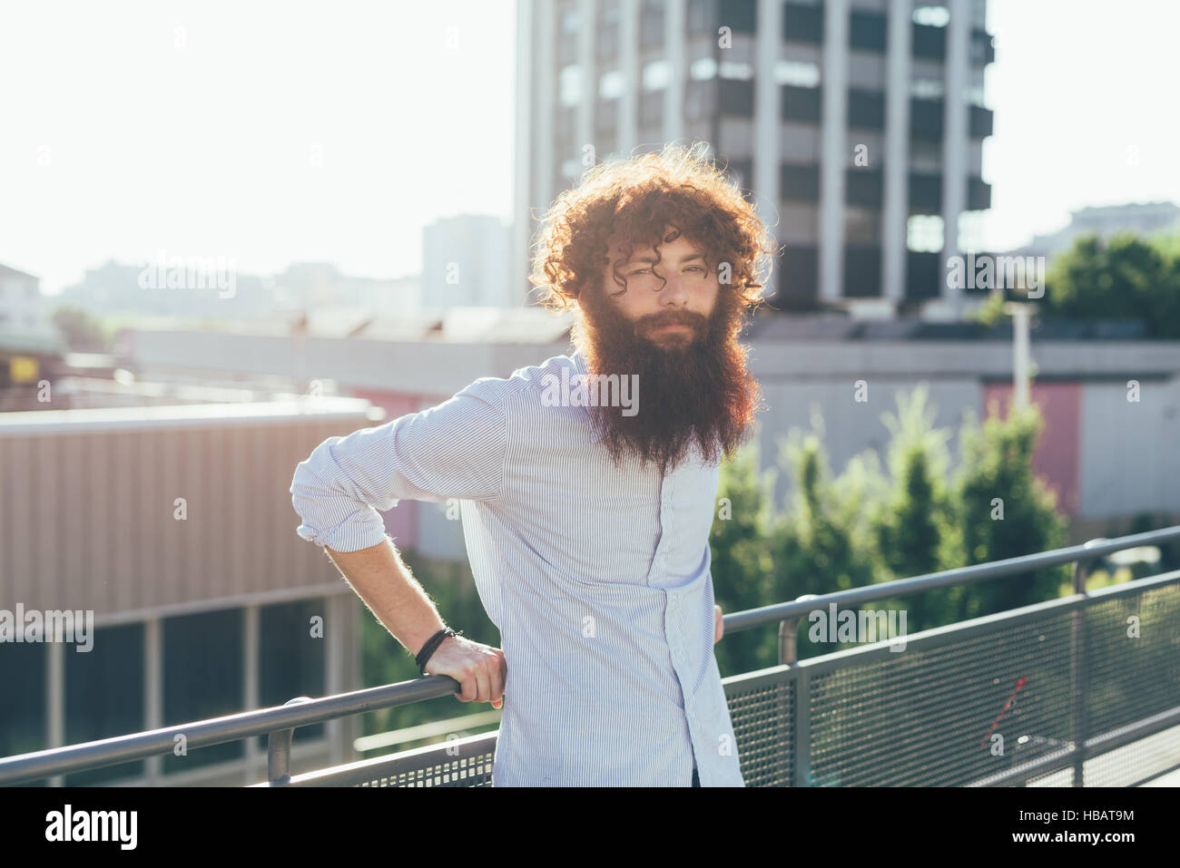 Ritratto di giovane maschio hipster con i capelli rossi e la barba sulla terrazza sul tetto Foto Stock