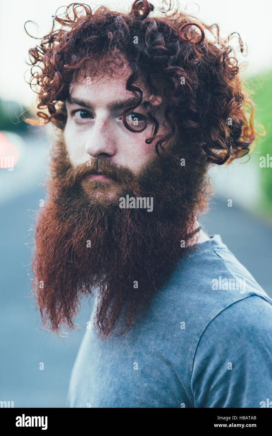 Ritratto di capelli ricci, barbuto giovane maschio hipster Foto Stock