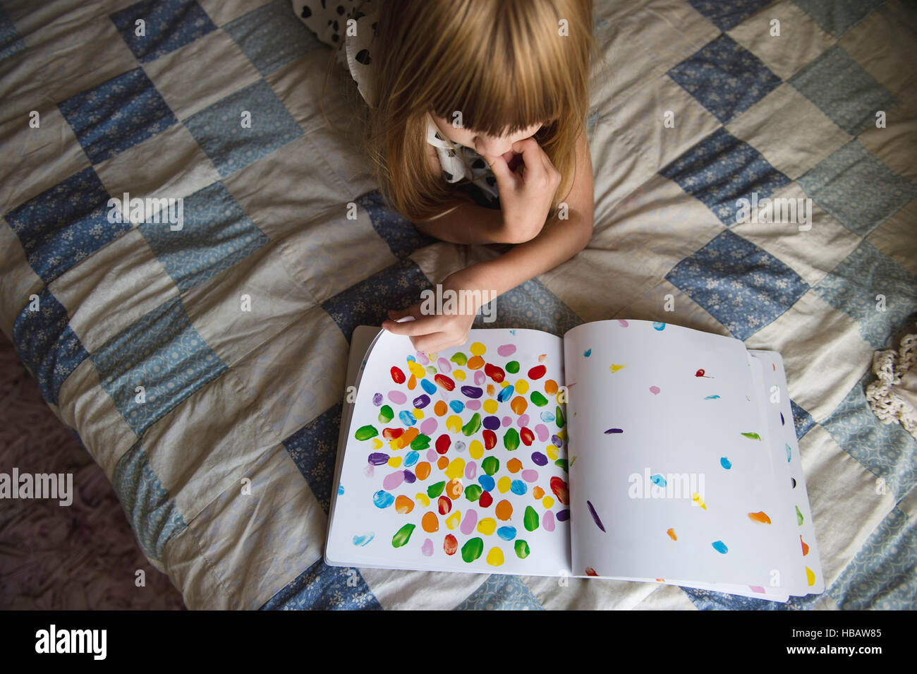 Ragazza giovane la posa sul letto libro di lettura Foto Stock
