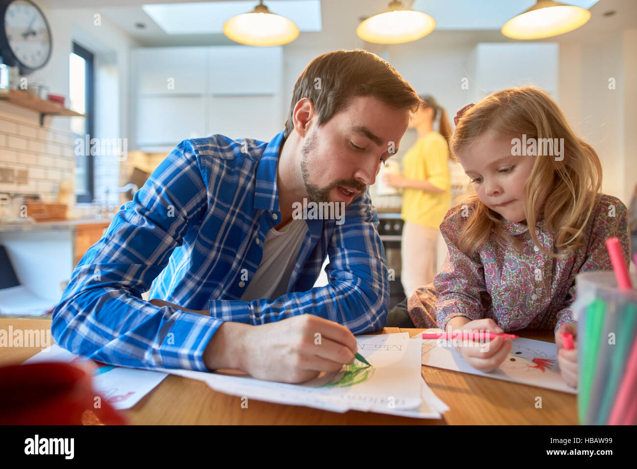 Metà uomo adulto e figlia colorazione a tavola in cucina Foto Stock