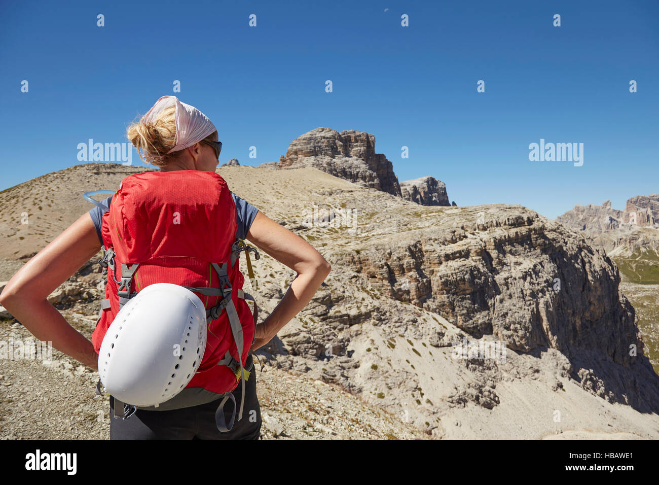 Vista posteriore di un escursionista femmina con le mani sui fianchi in Dolomiti, Sesto, Alto Adige, Italia Foto Stock
