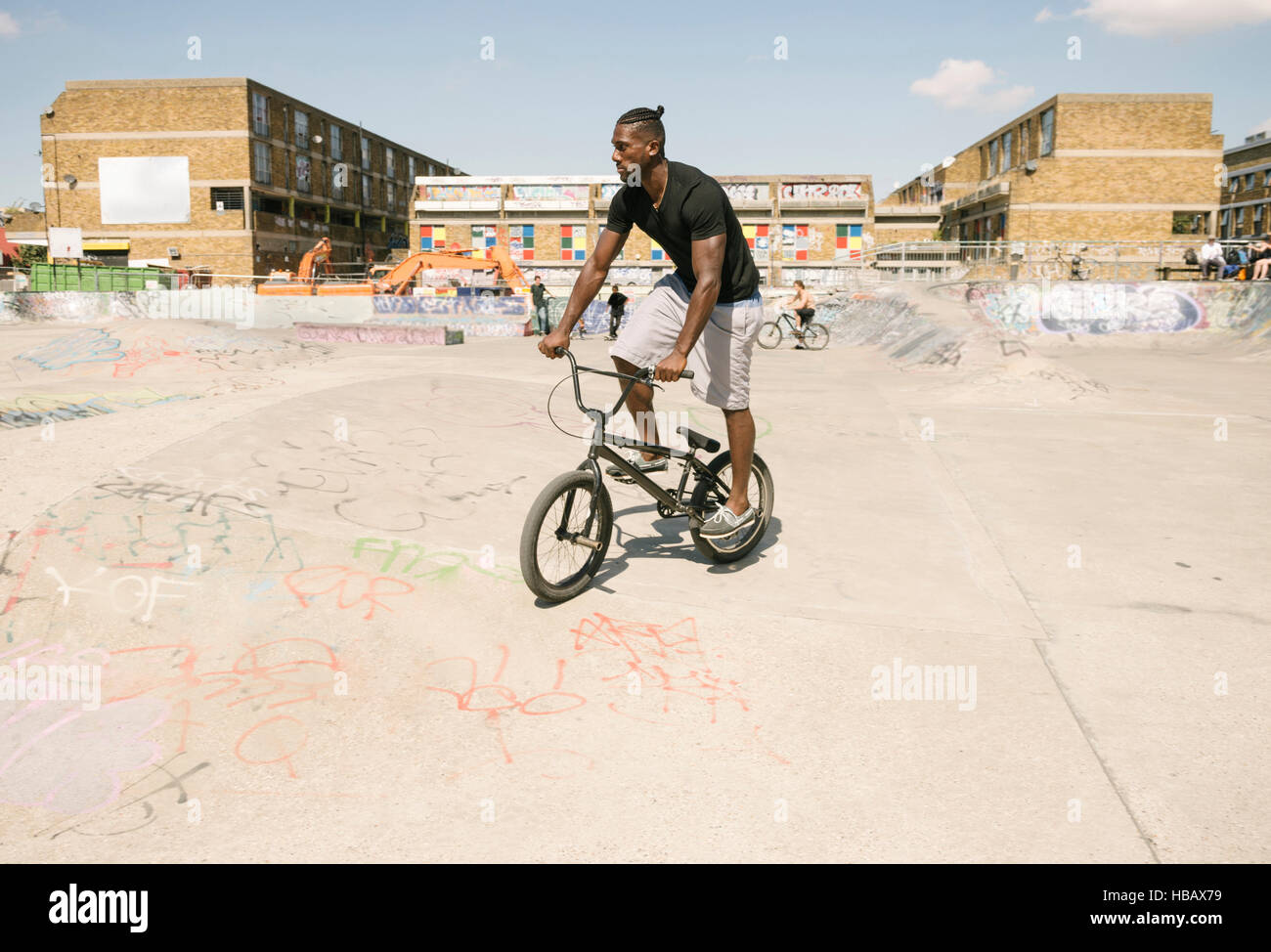 Giovane uomo di equitazione biciclette BMX in skatepark Foto Stock