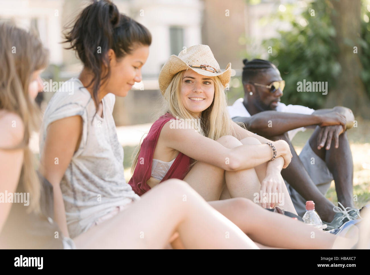 Giovane uomo e donna Amici chattare in posizione di parcheggio Foto Stock