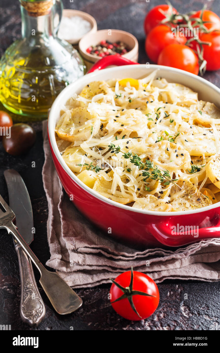 Patate gratinate, nel piatto rustico. Deliziose le patate a fette con cipolla, pomodoro, aglio, erbe e carne di pollo. Foto Stock