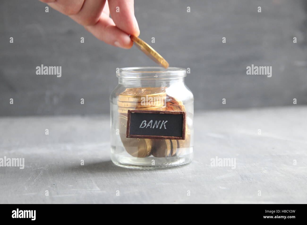Mettere mano medaglia d'oro nel vaso del frullatore, il risparmio di denaro, gli investimenti, la banca idea. Foto Stock