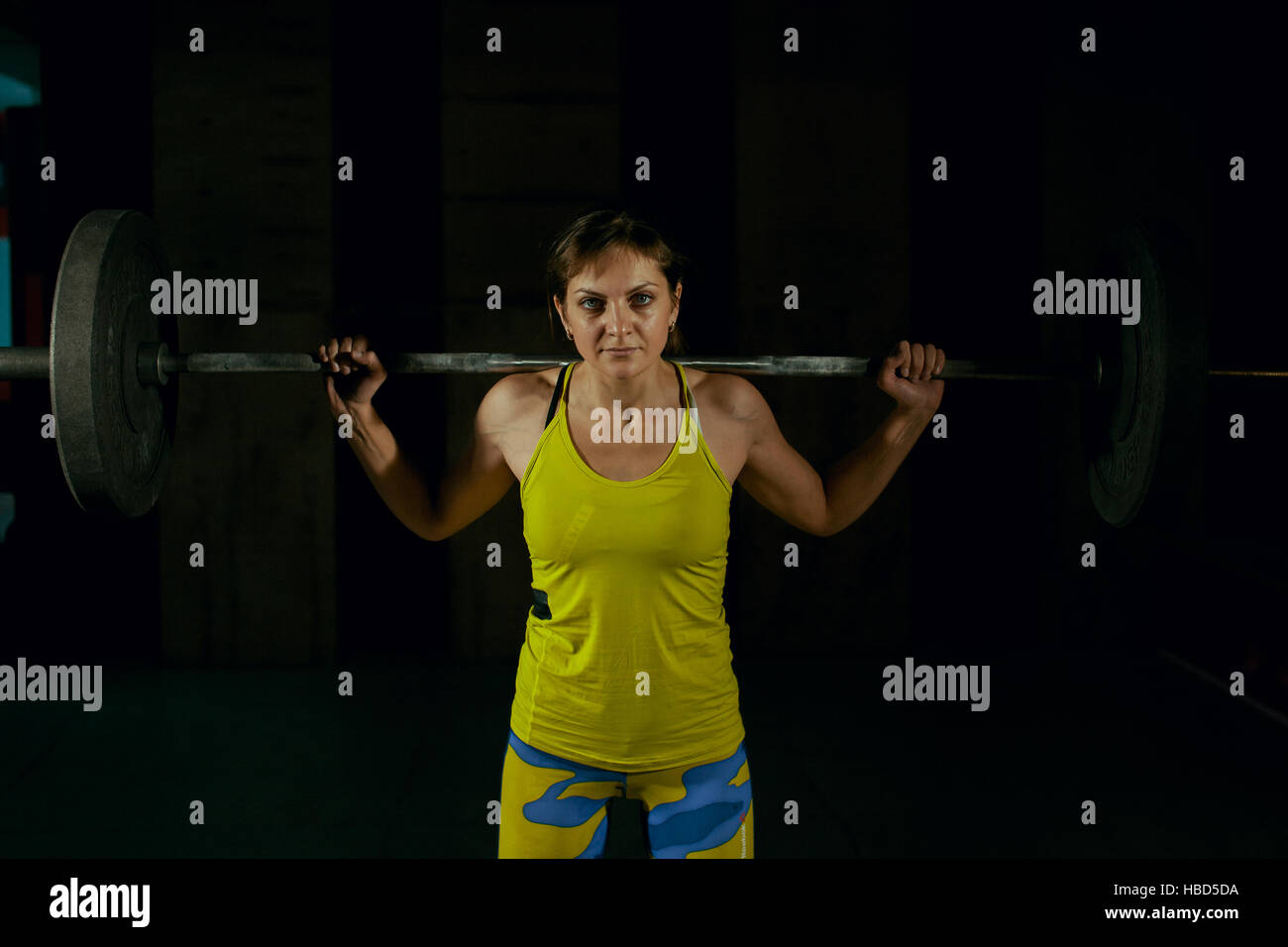 Ragazza giovane facendo per impieghi pesanti squat in palestra con barbell. Foto Stock