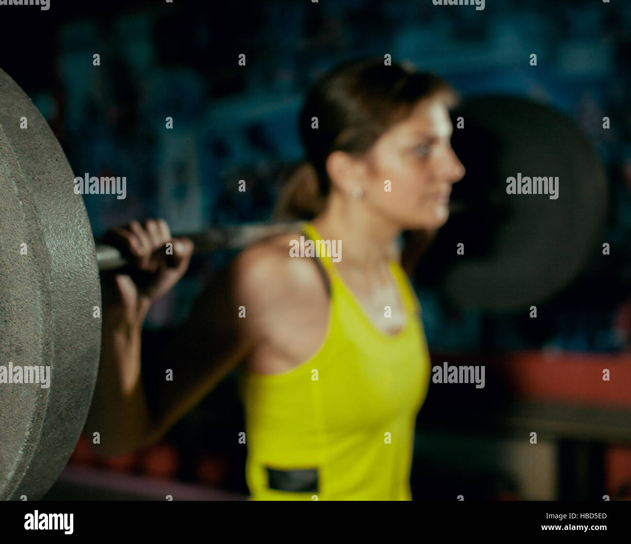 Ragazza giovane facendo per impieghi pesanti squat in palestra con barbell. Foto Stock