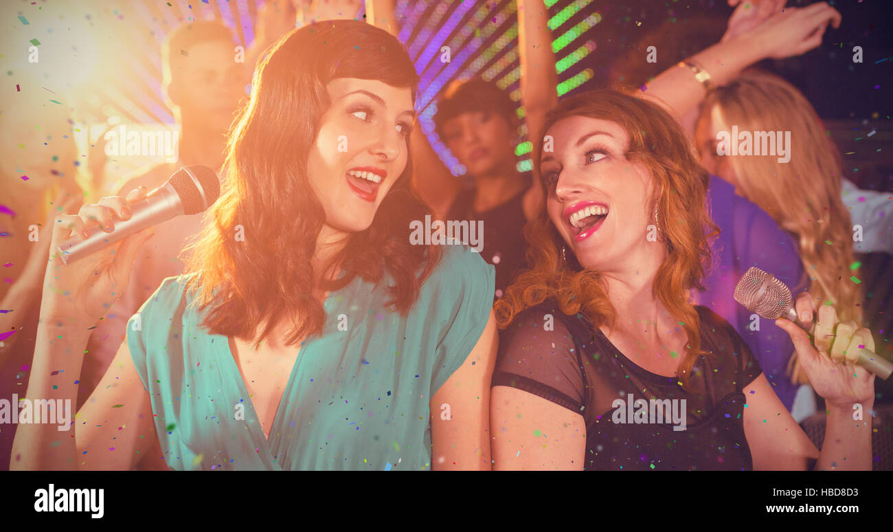 Immagine composita di due belle donne che cantano canzone insieme Foto Stock
