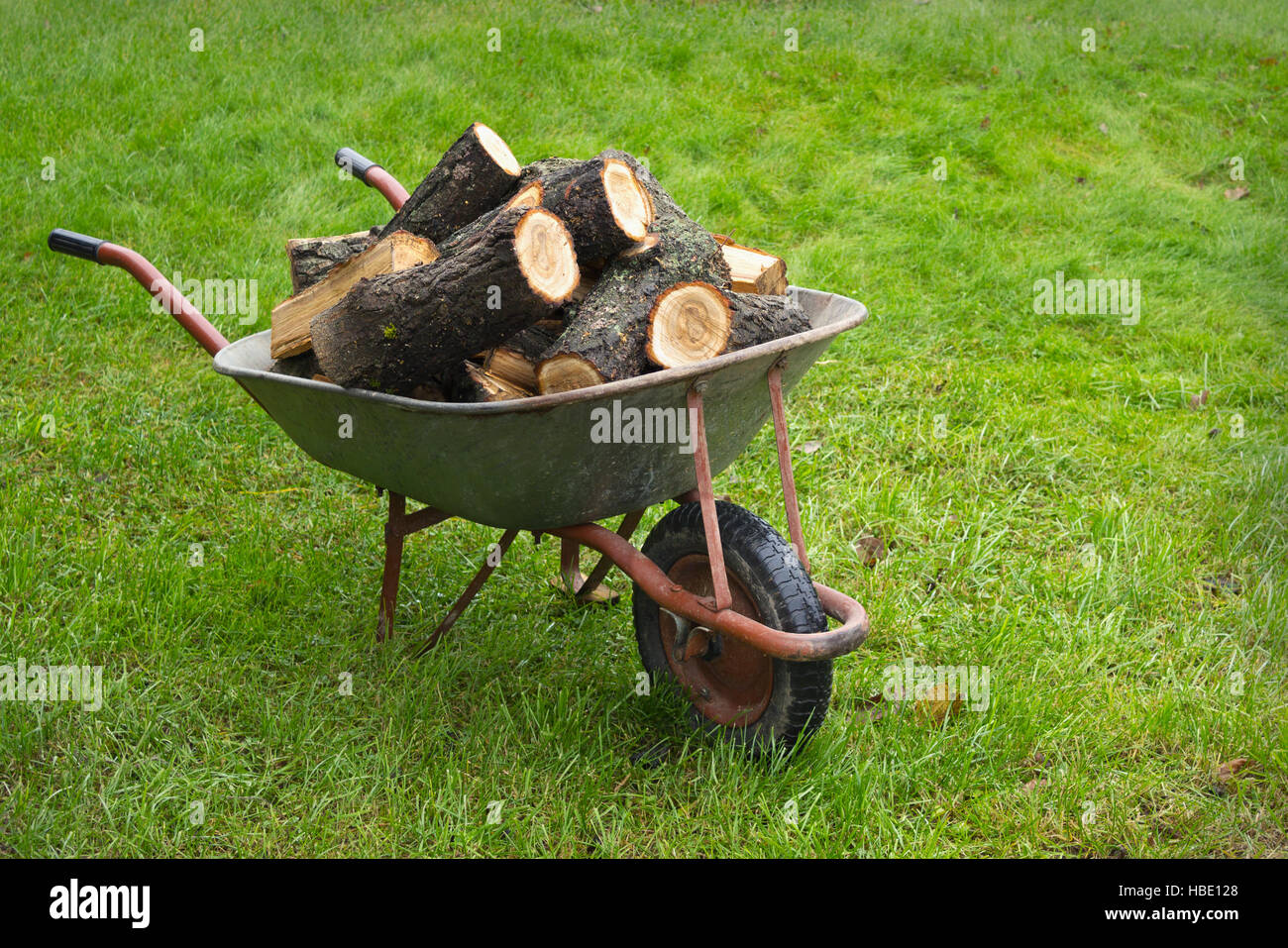Una vecchia carriola piena di legna da ardere Foto stock - Alamy
