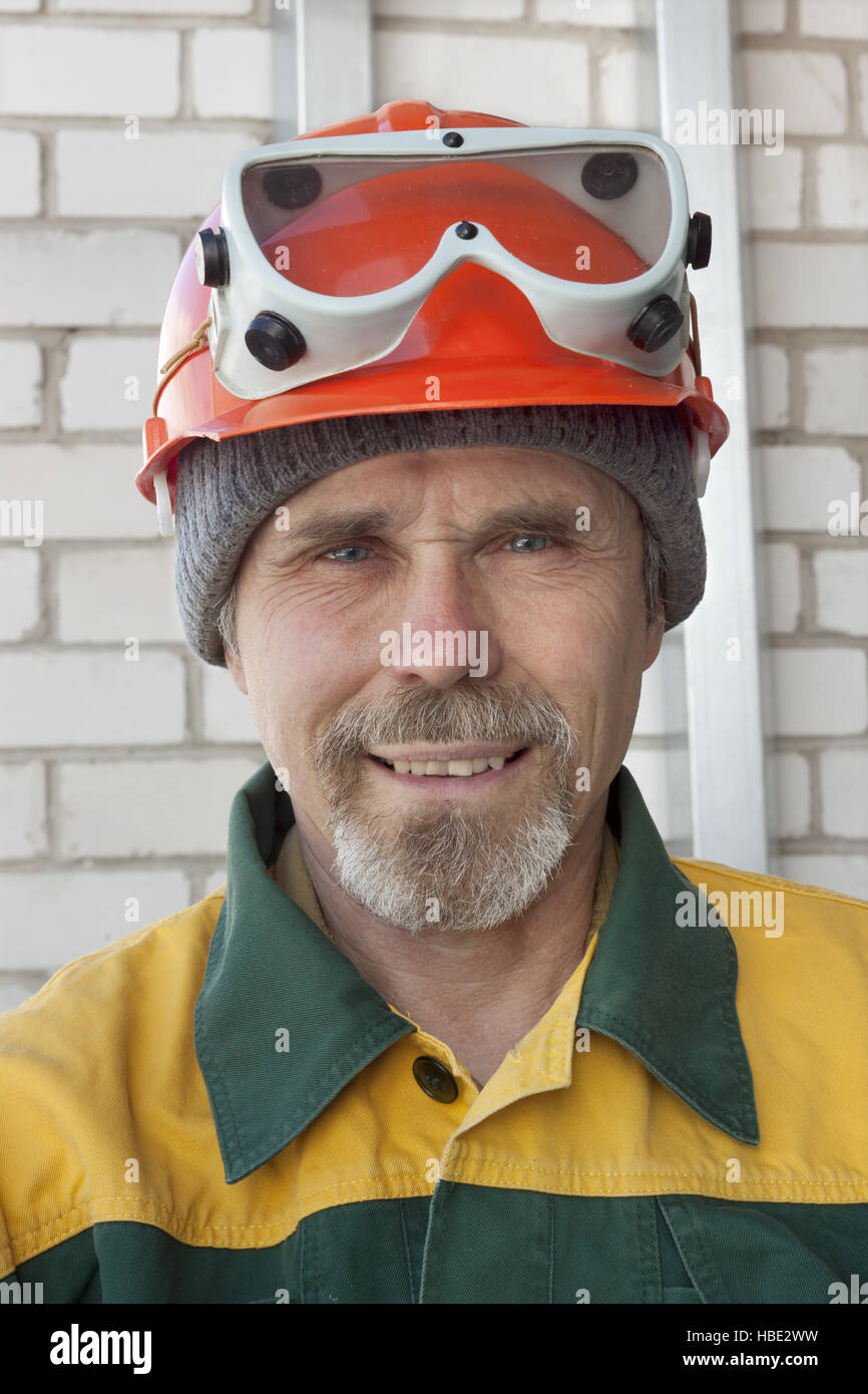 Un lavoratore anziano nel casco di protezione Foto Stock