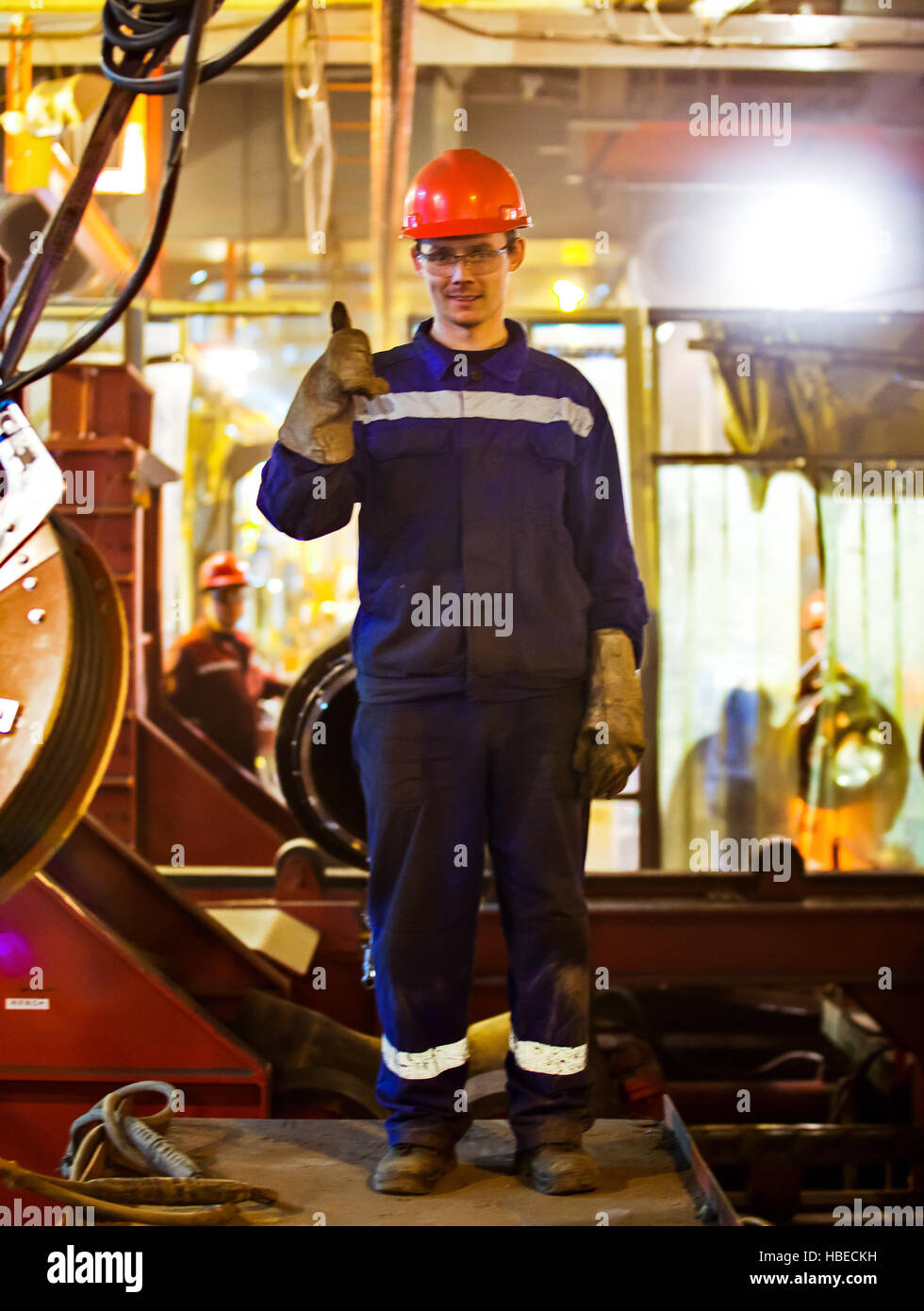 I lavoratori e i montatori saldatori in abbigliamento protettivo e un casco. Lavorando in esercizio impianti industriali. Foto Stock