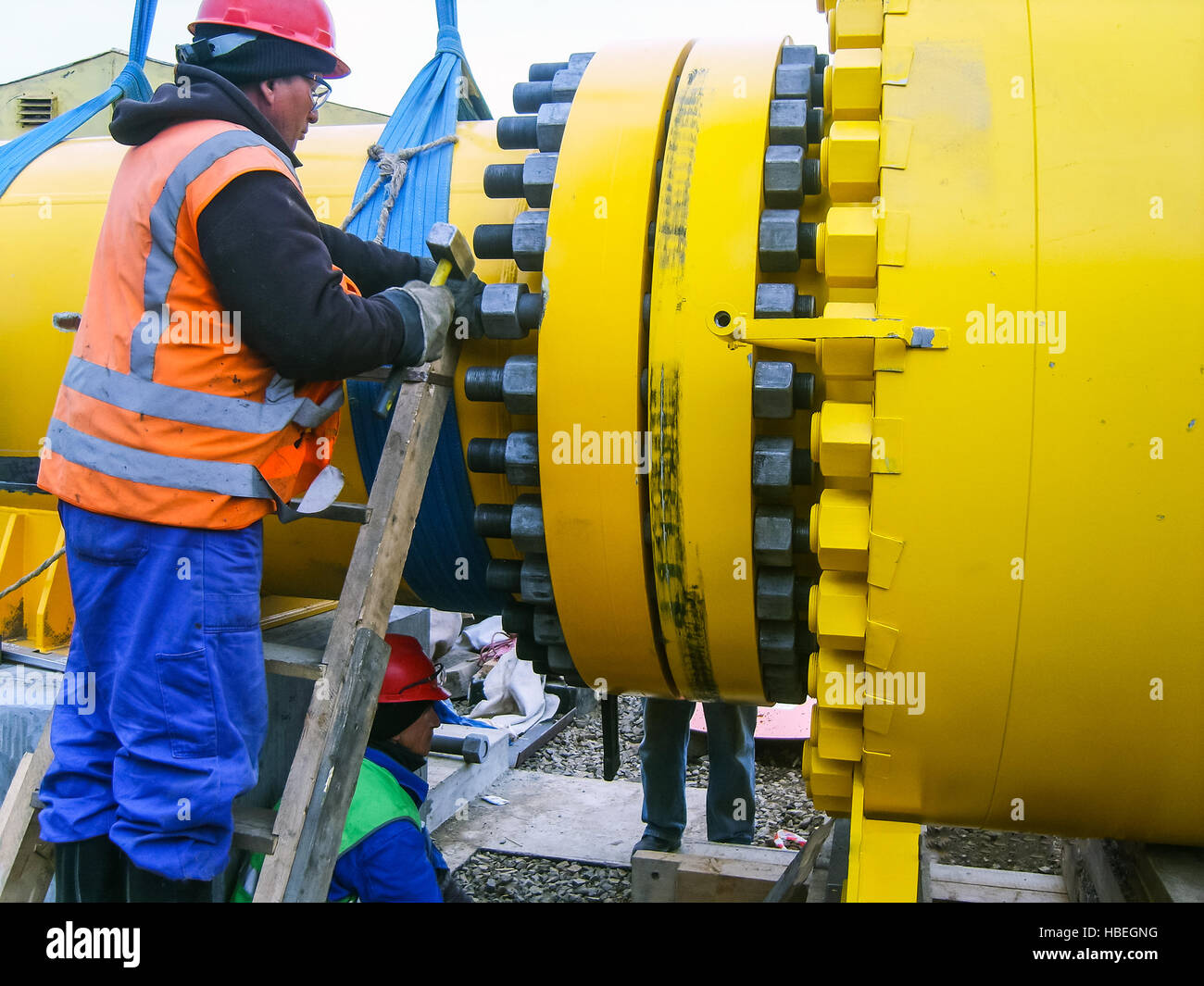 Lavorare serrare i dadi sulla flangia. Foto Stock