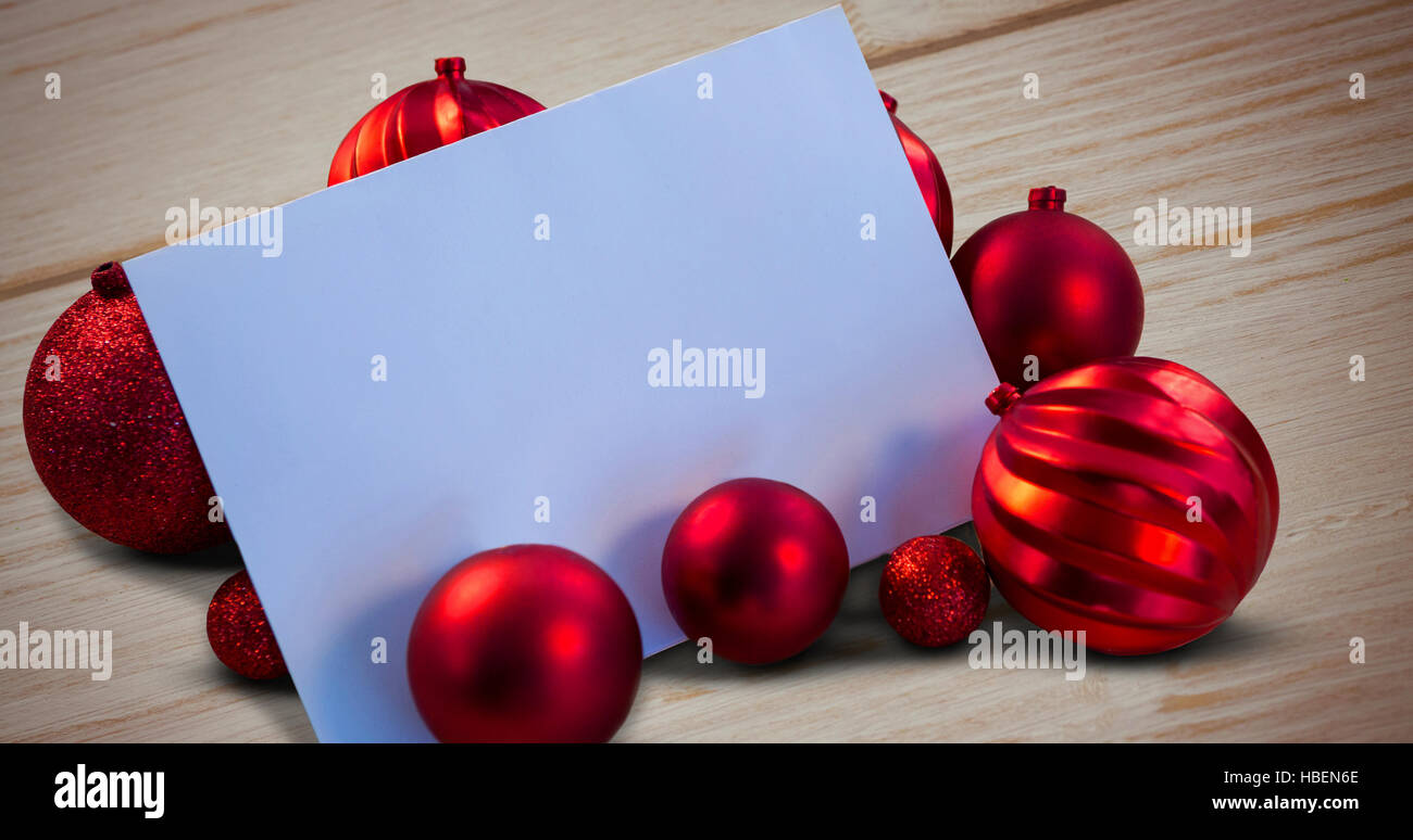 Immagine composita di natale rosso baubles circostante pagina bianca Foto Stock