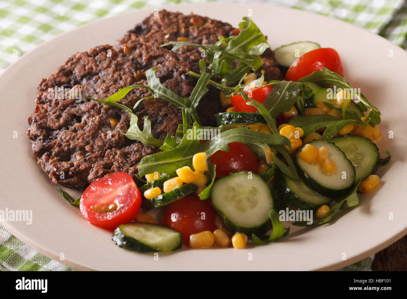 Cibo vegetariano: chicco nero hamburger e insalata di verdure fresche close-up su una piastra orizzontale. Foto Stock