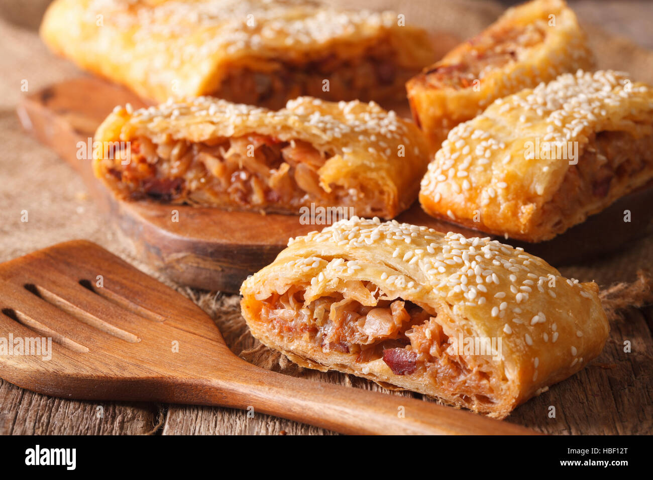 Fette di torta con cavolo e salsicce macro sul tavolo orizzontale. Foto Stock