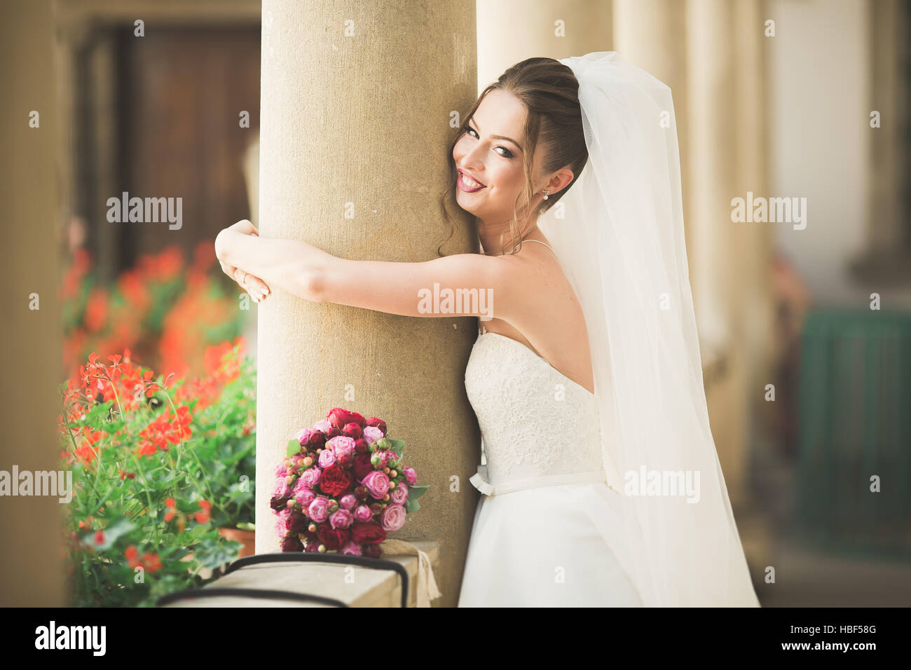 Splendida sposa con un lussuoso abito bianco in posa nella città vecchia Foto Stock