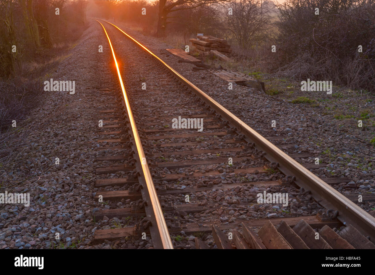 Sunsetting e riflettendo sulle rotaie di una ferrovia a binario unico nel Nord Kent. Vicino a Higham Foto Stock