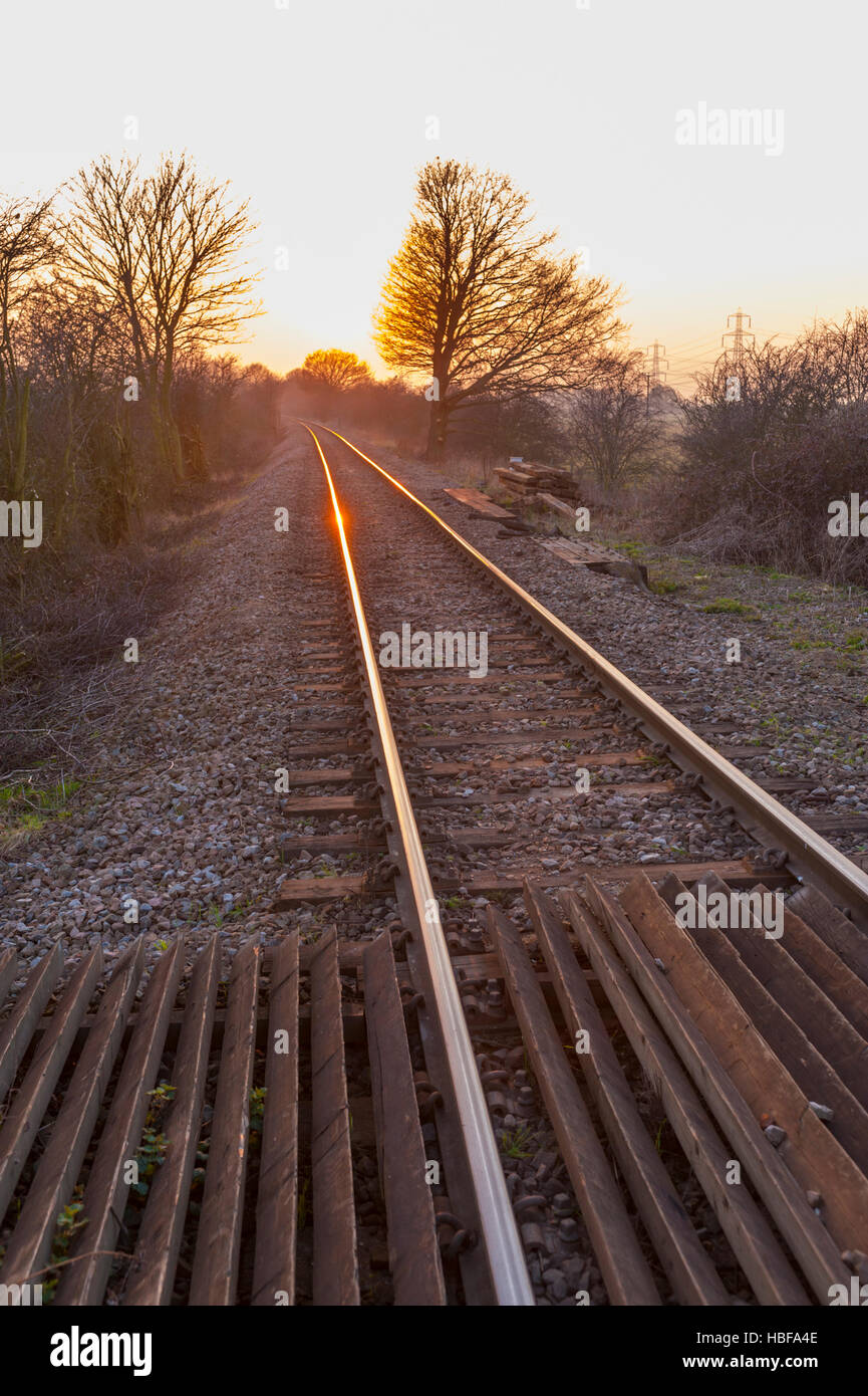 Sunsetting e riflettendo sulle rotaie di una ferrovia a binario unico nel Nord Kent. Vicino a Higham Foto Stock