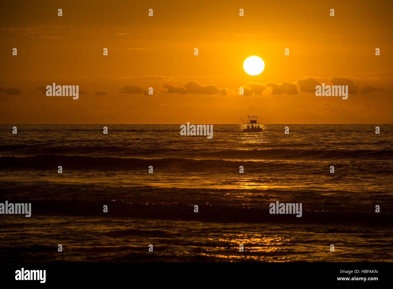 Una barca da pesca torna a Saint-Gilles-les-Bains sull isola di Reunion al tramonto. Foto Stock