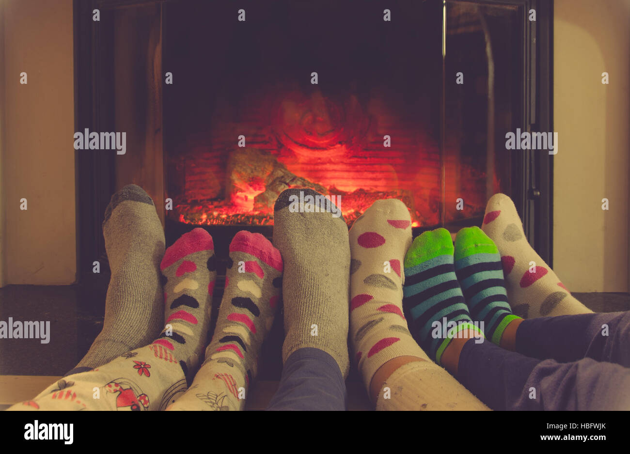 Piedi in calze di tutta la famiglia e rilassante il riscaldamento da caminetto Foto Stock
