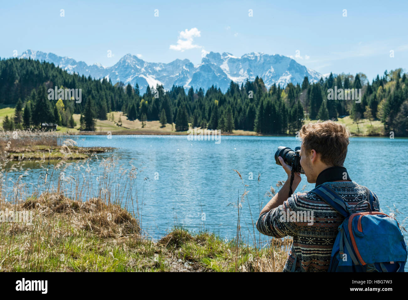 Escursionista a fotografare il lago Geroldsee, Wagenbrüchsee, Karwendel, Werdenfelser Land, Alta Baviera, Baviera, Germania Foto Stock