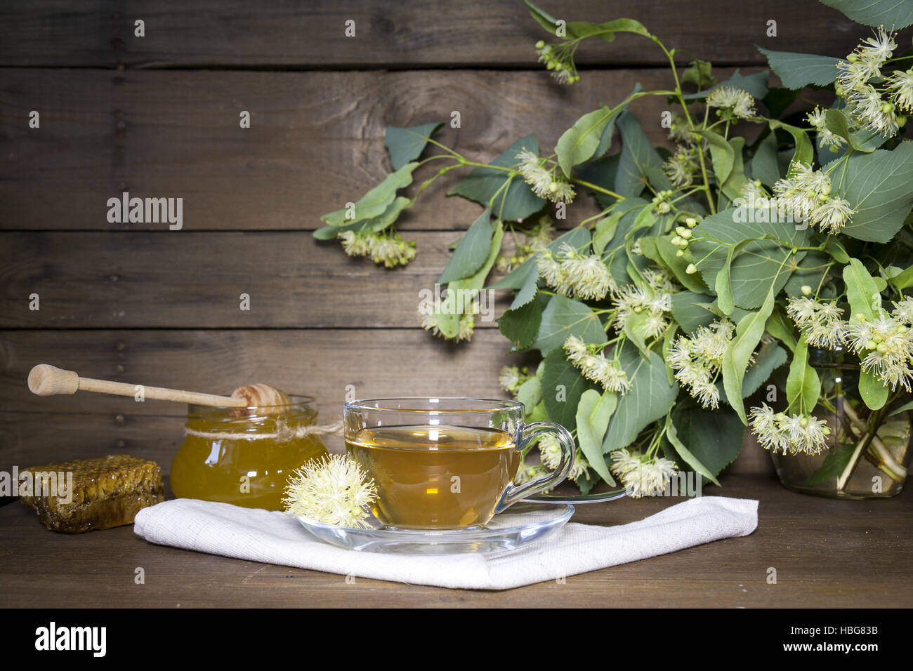 Linden tè in tazza di vetro e jar con miele Foto Stock