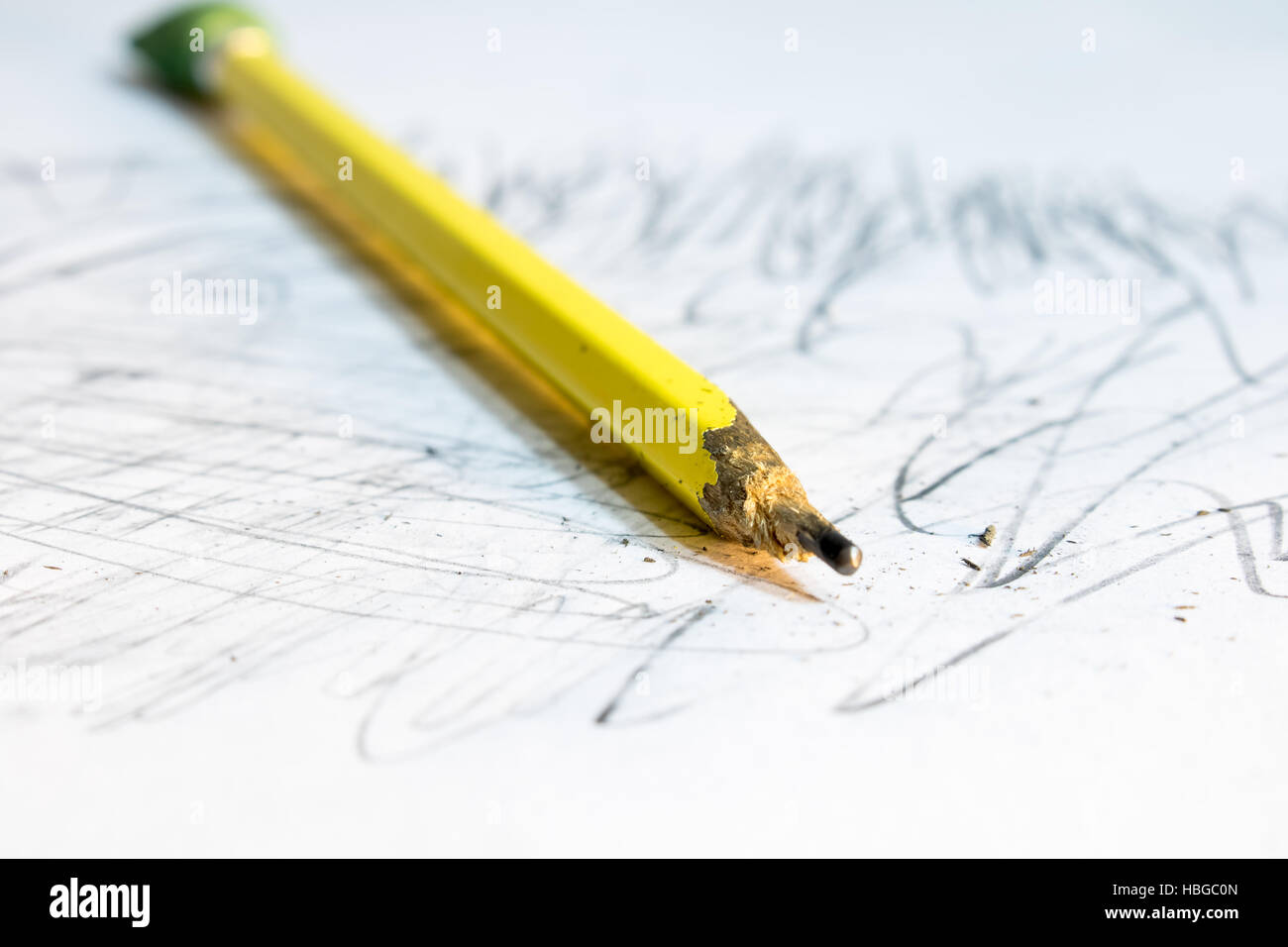 Una matita unsharpened ubicazione su un scarabocchiati su pezzo di carta Foto Stock