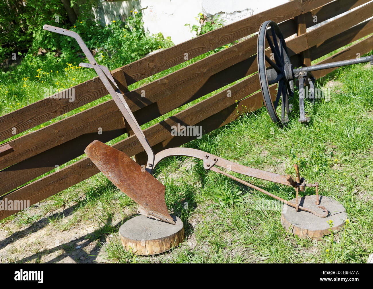 Aratro di ferro alla recinzione di legno giorno di estate Foto Stock