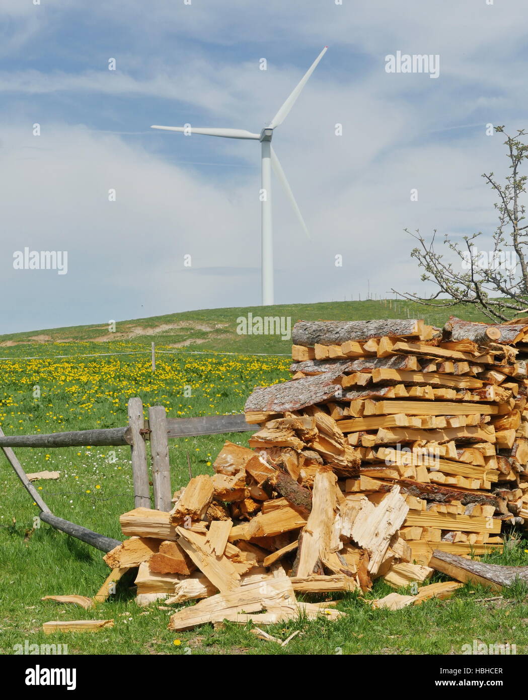 Woodpile con wind power station su sfondo Foto Stock