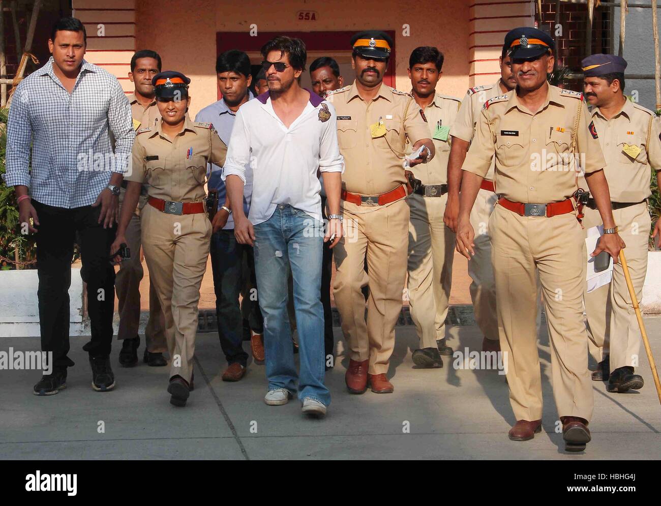 Bollywood attore Shahrukh Khan circondato da uomini di polizia e la sicurezza donna dopo il voto alle elezioni di Lok Sabha, a Mumbai, India Foto Stock